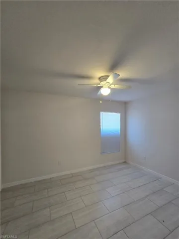 Spare room featuring baseboards and a ceiling fan