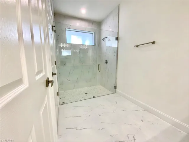 Bathroom featuring a shower with door and tile patterned flooring