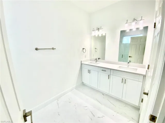 Bathroom with tile patterned floors and double vanity