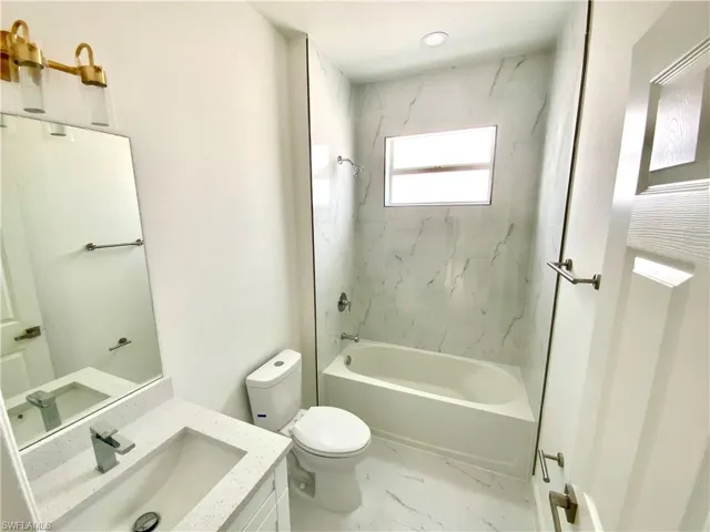 Full bathroom featuring tiled shower / bath combo, vanity, tile patterned flooring, and toilet