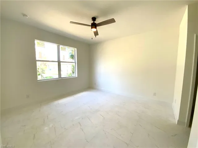 Tiled spare room with ceiling fan