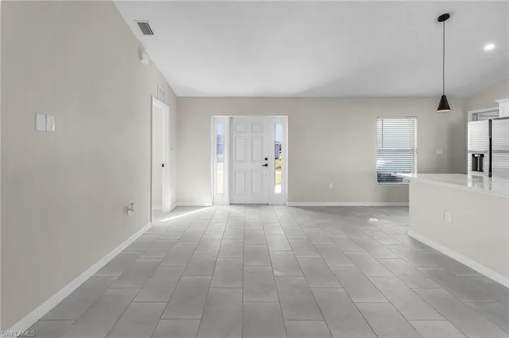 Foyer with baseboards and vaulted ceiling