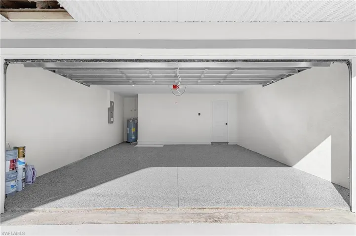 Garage featuring water heater and electric panel
