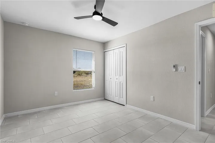 Unfurnished bedroom featuring a ceiling fan, a closet, and a textured wall