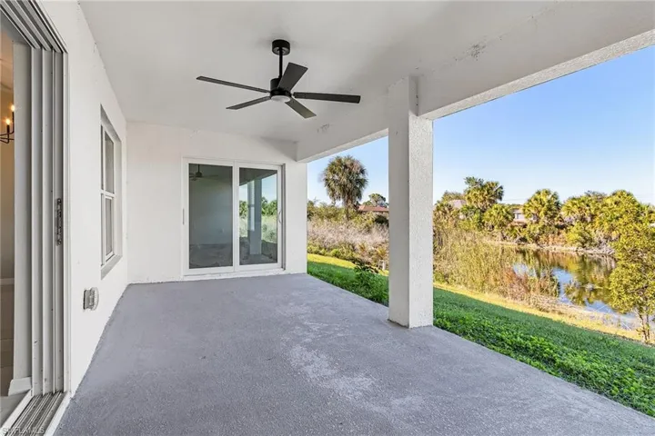 View of patio with ceiling fan and a water view