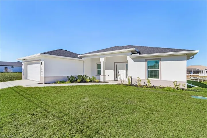 Prairie-style house featuring a front lawn, stucco siding, a porch, and concrete driveway