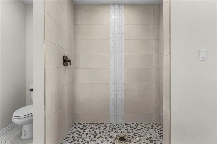 Bathroom featuring a stall shower and a textured wall