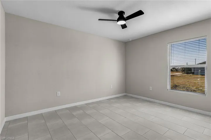 Empty room with baseboards and ceiling fan
