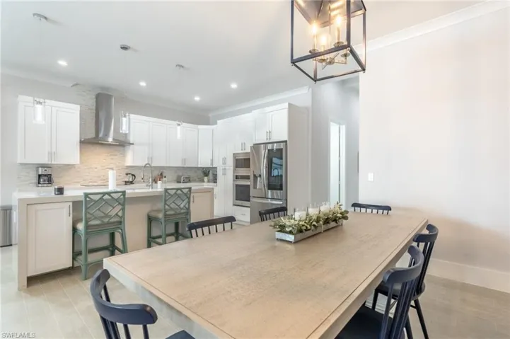 Dining area with crown molding, a chandelier, and recessed lighting