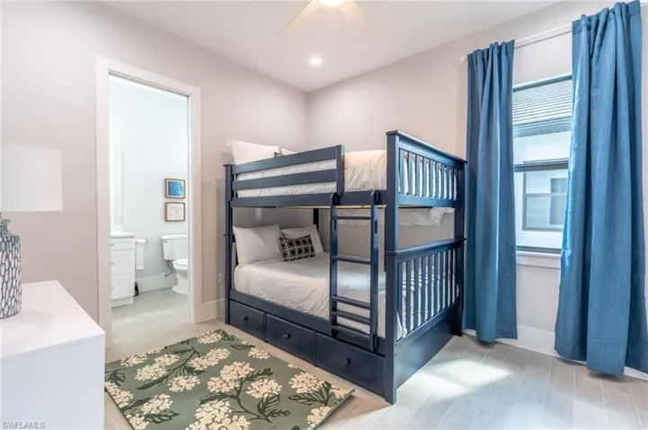 Bedroom with a ceiling fan and connected bathroom