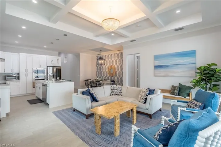 Living area with a chandelier, coffered ceiling, recessed lighting, light wood finished floors, and beam ceiling