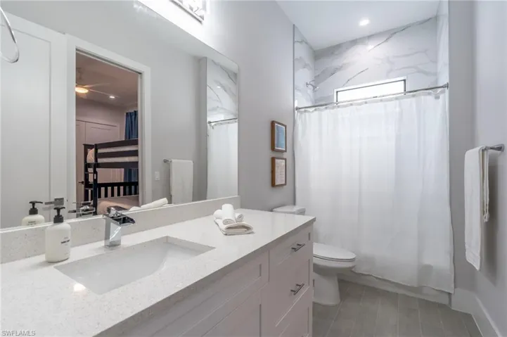 Ensuite bathroom with vanity, recessed lighting, and ceiling fan