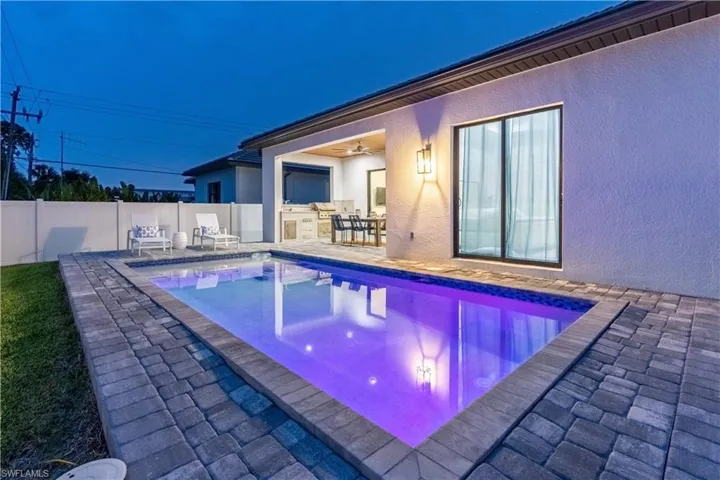 View of swimming pool with a patio, exterior kitchen, and a fenced backyard