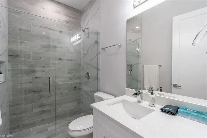 Full bathroom with vanity and a marble finish shower