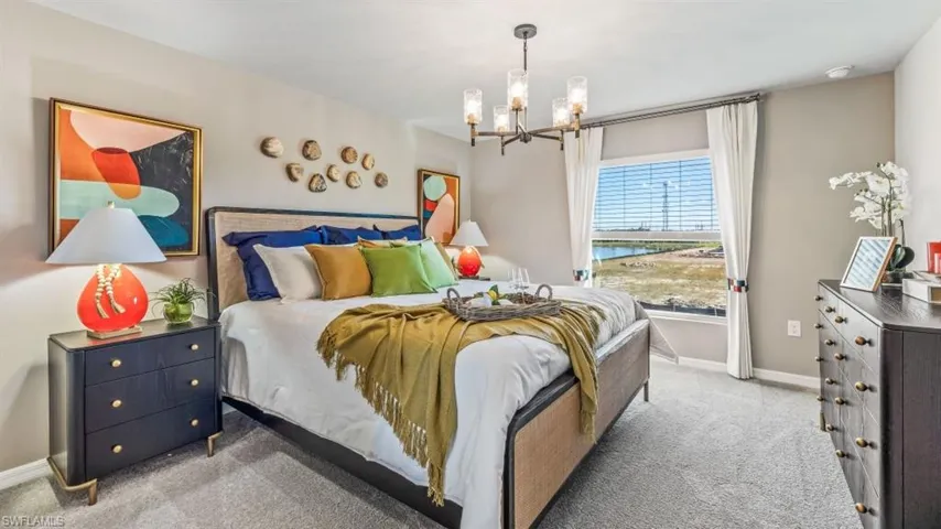 Carpeted bedroom featuring a chandelier