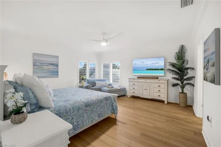 Spacious primary bedroom with sitting area and a TV