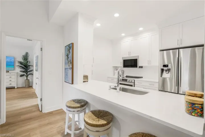 Open concept featuring stainless steel appliances and a breakfast bar