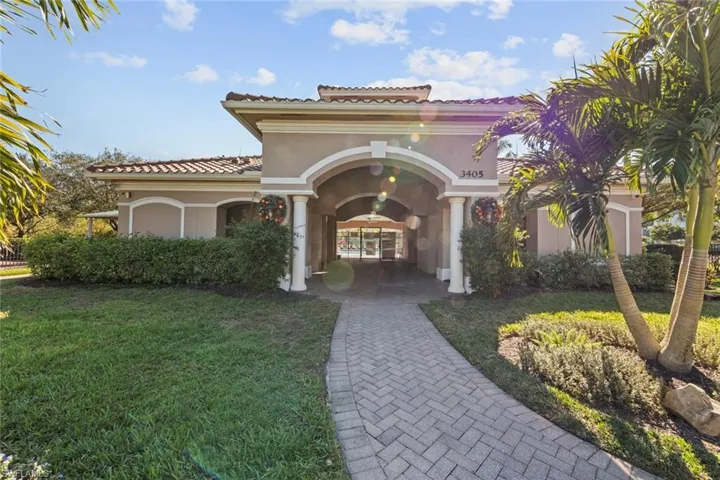View of front of property featuring a front yard, stucco siding, and a tile roof
