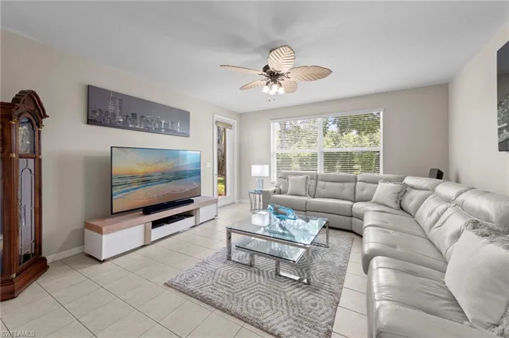 Living room featuring light tile patterned floors and ceiling fan