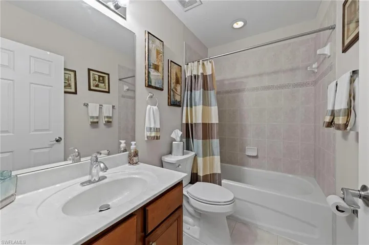 Bathroom featuring vanity, tile patterned floors, and shower / tub combo