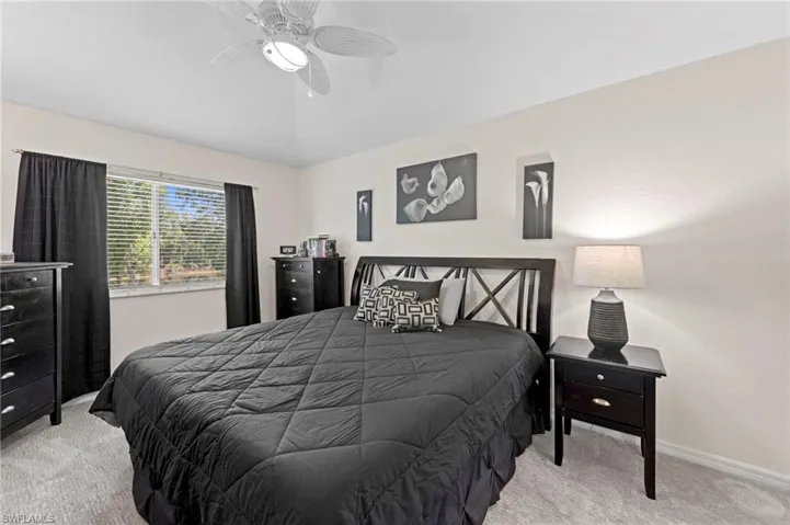 Bedroom with carpet floors, ceiling fan, and lofted ceiling