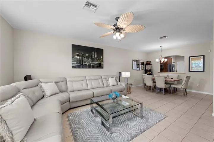 Living area featuring ceiling fan, a chandelier, and light tile patterned floors