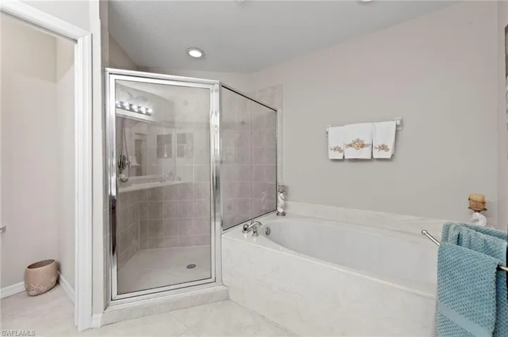 Full bath with a bath, a stall shower, and tile patterned flooring