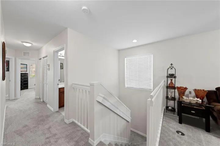Hall with an upstairs landing and light carpet