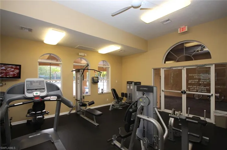 Gym featuring ceiling fan and baseboards