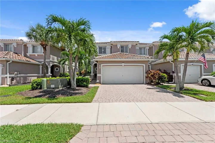 Mediterranean / spanish-style home with decorative driveway, a residential view, stucco siding, a garage, and a tiled roof