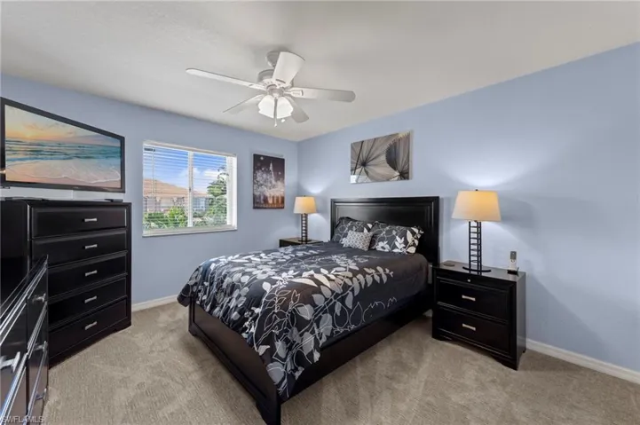 Bedroom with light colored carpet and a ceiling fan
