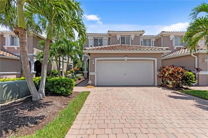 Mediterranean / spanish-style home featuring stucco siding, decorative driveway, a tiled roof, and a garage