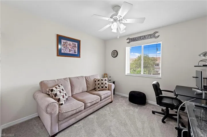 Carpeted home office with baseboards and ceiling fan