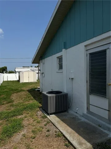 View of property exterior with central AC and a storage shed