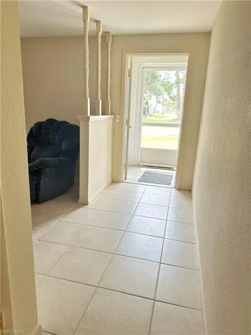 Doorway featuring light tile floors