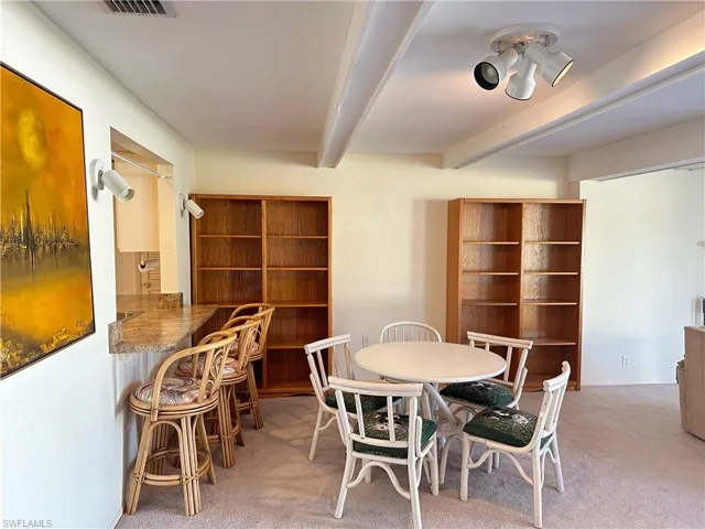 Dining space featuring beamed ceiling and carpet floors