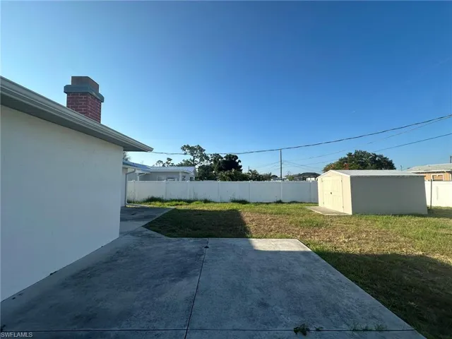 View of yard with a shed and a patio area looking North