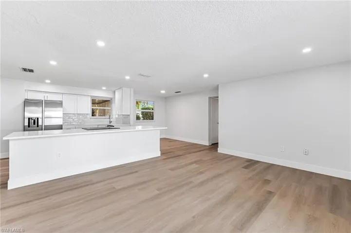 Unfurnished living room with light hardwood / wood-style floors and a textured ceiling