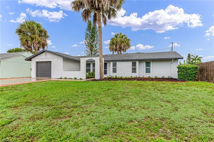 Ranch-style home featuring a front lawn and a garage