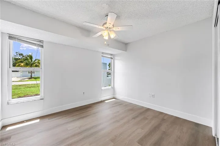 Empty room with a textured ceiling, ceiling fan, and hardwood / wood-style floors