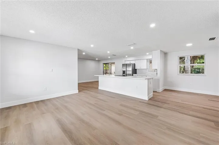 Unfurnished living room featuring light hardwood / wood-style floors and a textured ceiling