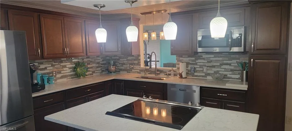 Kitchen featuring, quartz counters,  and tile backsplash