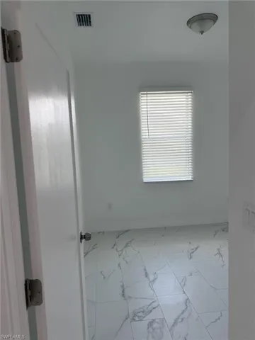 Empty room with marble finish floors and baseboards