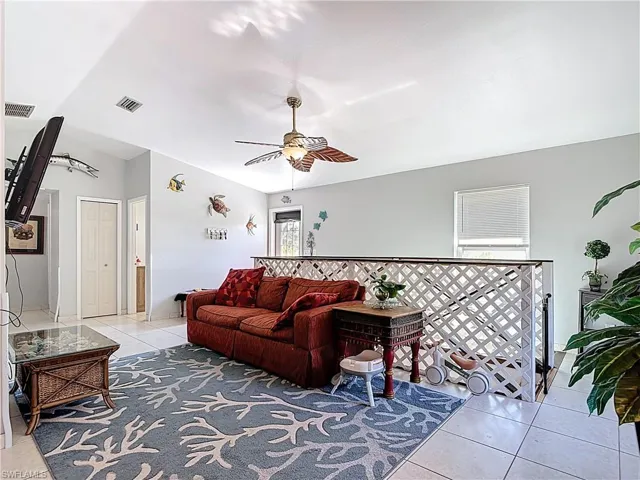 Living area with a ceiling fan and light tile patterned floors