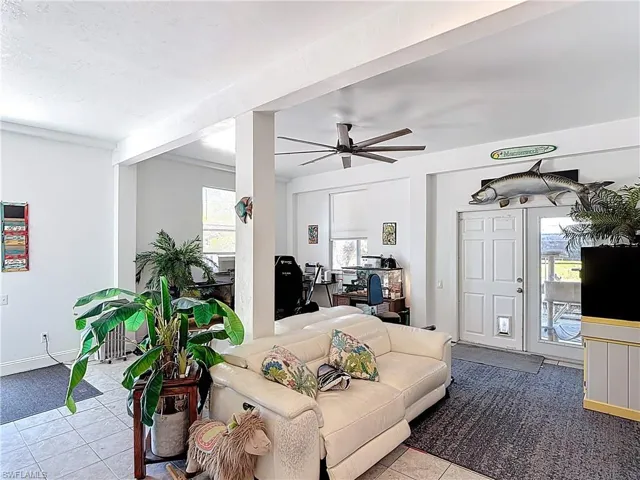 Living area featuring a ceiling fan and tile patterned flooring