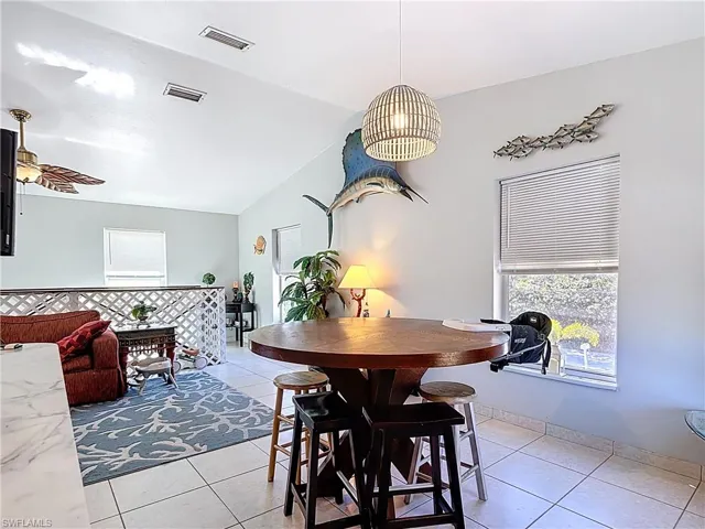 Dining space featuring lofted ceiling, light tile patterned flooring, and a ceiling fan