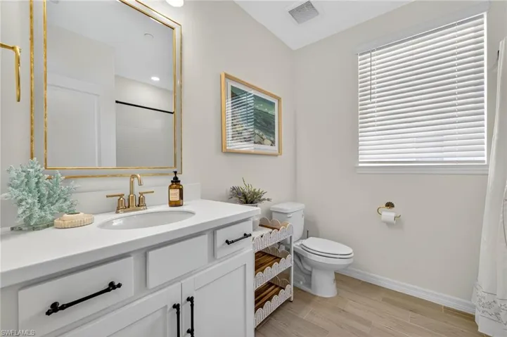 Full bathroom featuring light wood-style flooring, vanity, a shower with shower curtain, and recessed lighting
