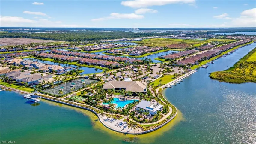 Aerial view of residential area featuring a pool and a large body of water