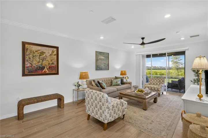 Living area featuring ornamental molding, wood tiled floors, ceiling fan, and recessed lighting