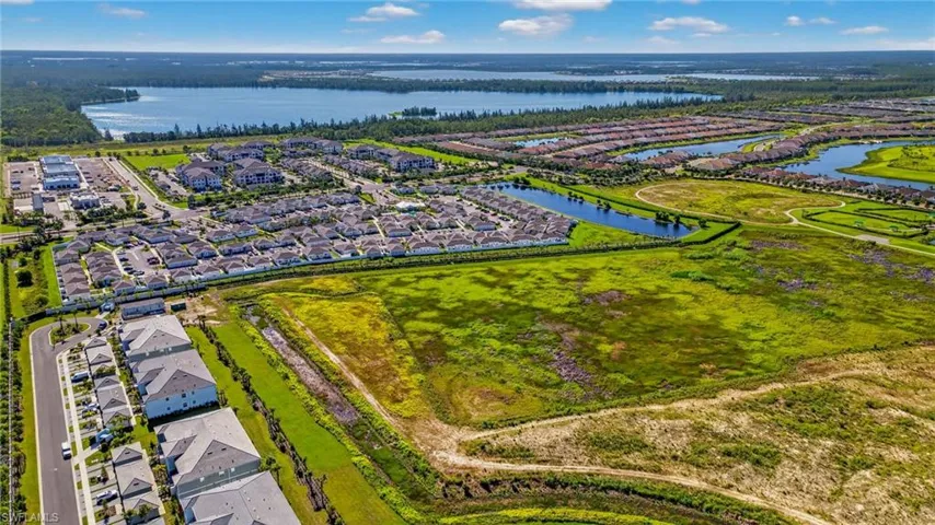 Aerial perspective of suburban area featuring a nearby body of water
